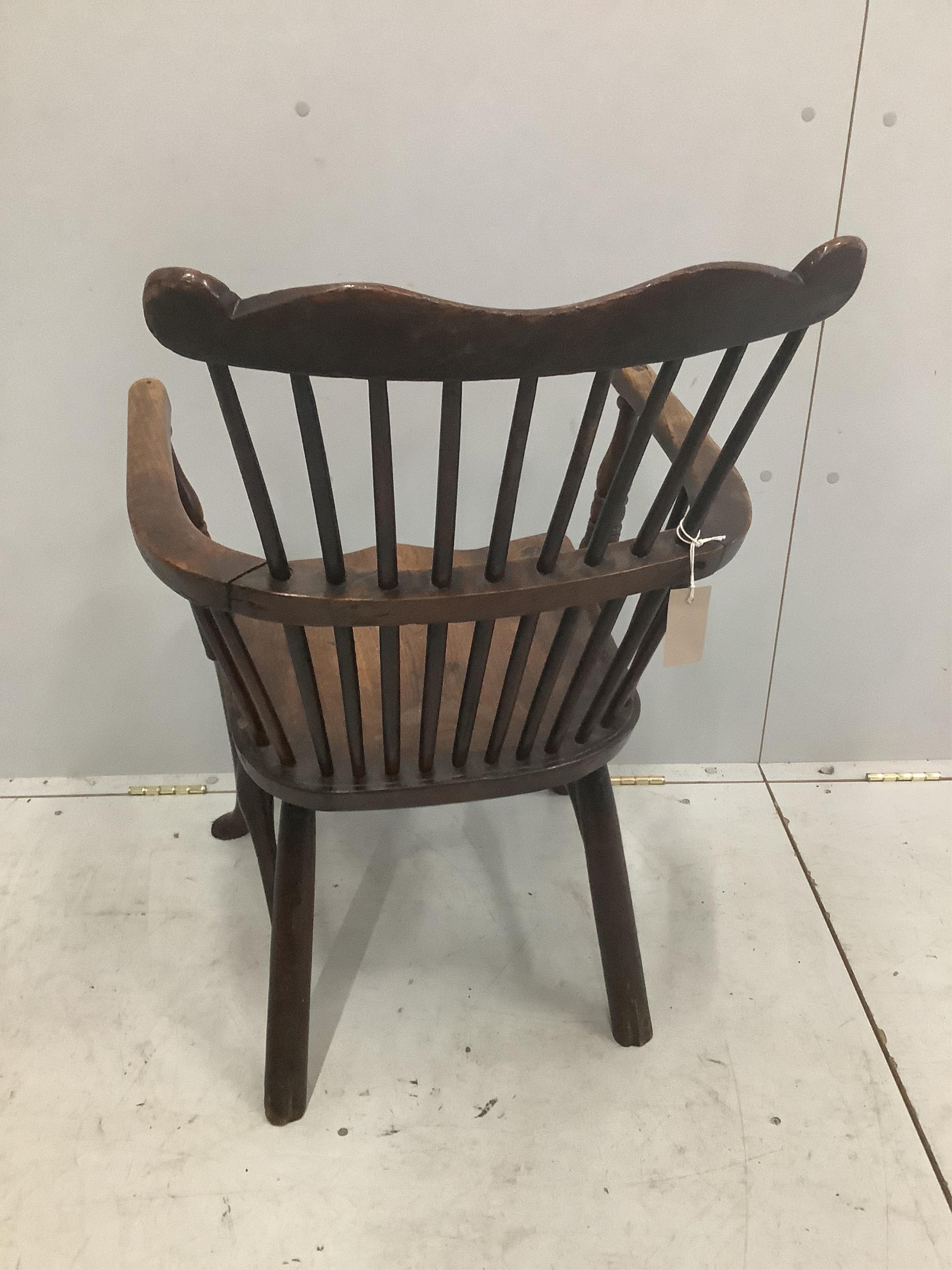 An early 18th century ash and elm primitive Windsor elbow chair on cabriole front legs, width 52cm, depth 43cm, height 89cm. Condition - fair